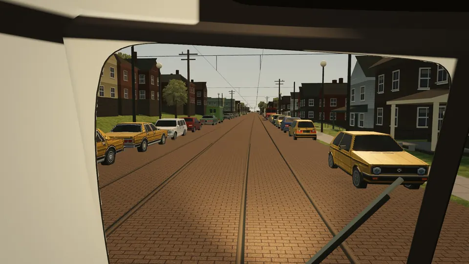 The view through a PCC's windscreen down Broadway, parked cars along both curbs