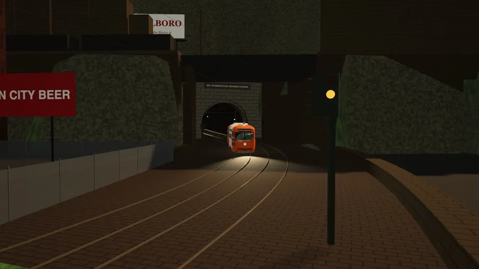 An orange and white PCC coming out of the Mt. Washington Transit Tunnel's north portal onto Carson Street